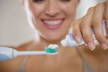 Woman Using Teeth Whitening Toothpaste